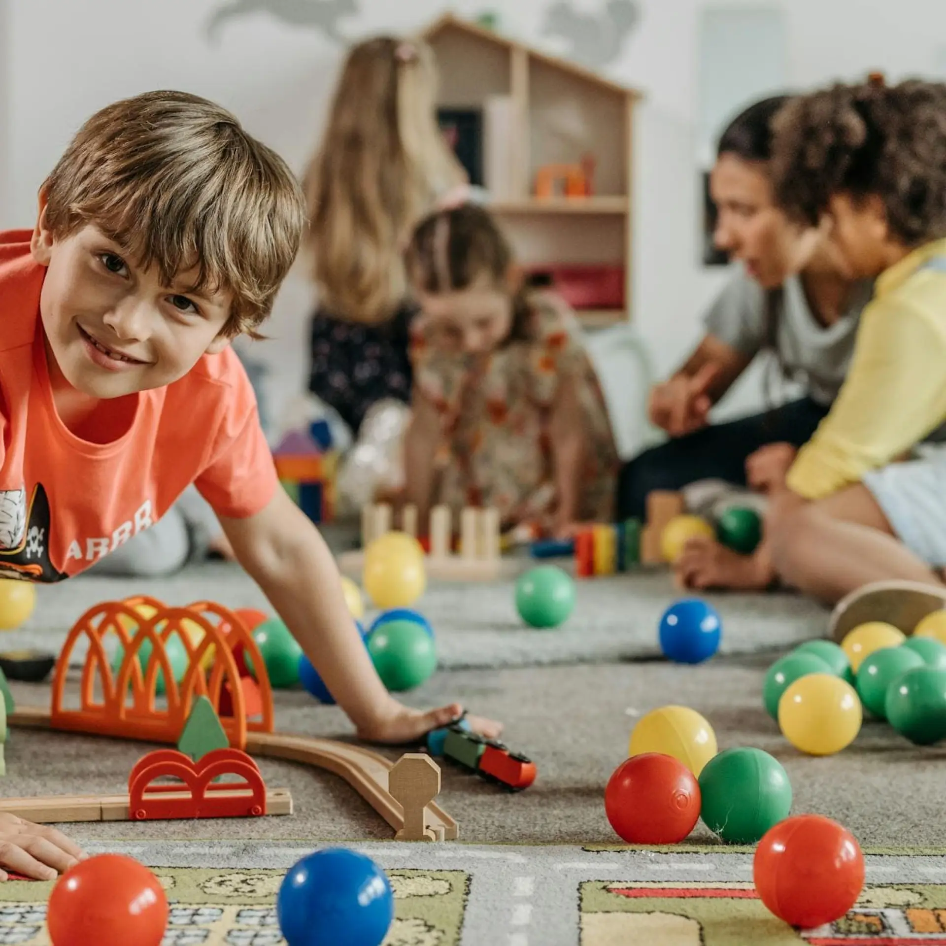 Children playing with colorful toys on the floor.
